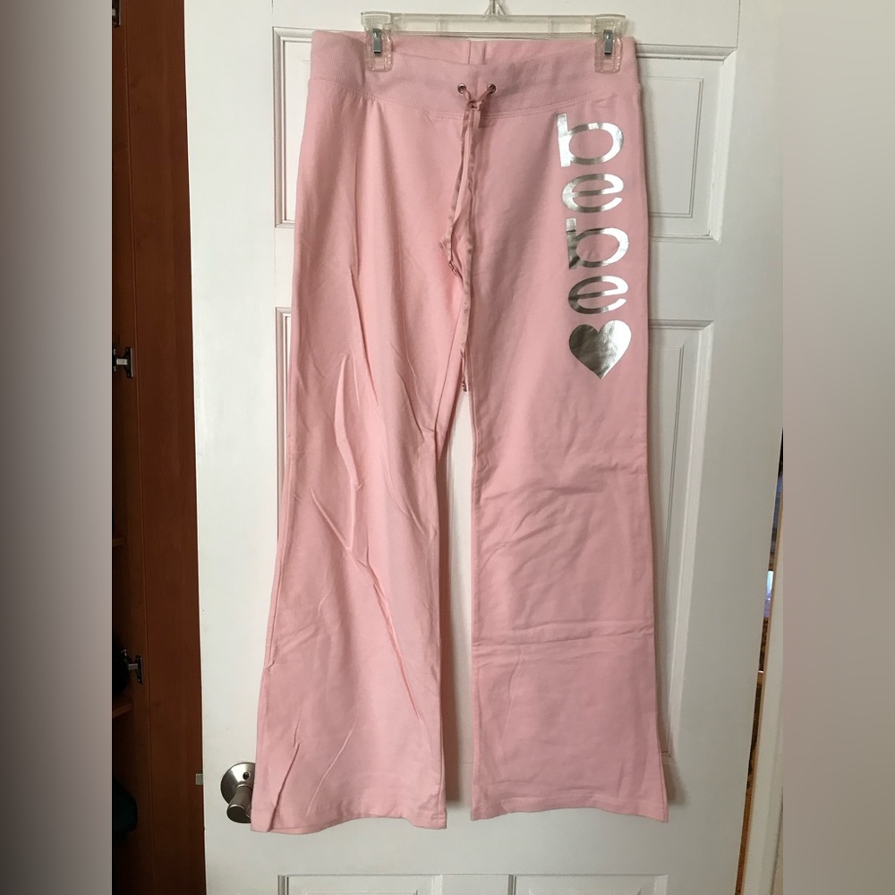Bebe light pink sport pants w/silver print. Sz M. New no tags.